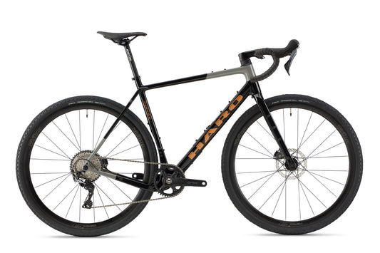 The Haro Bikes Buzzard Carbon 3 is a sleek black and gray gravel bike featuring drop handlebars, thick tires, a Shimano GRX Gruppe disc brake system, and a lightweight frame. Its minimalistic design showcases the brand logo prominently on the frame, making it ideal for any Gravel-Abenteuer.