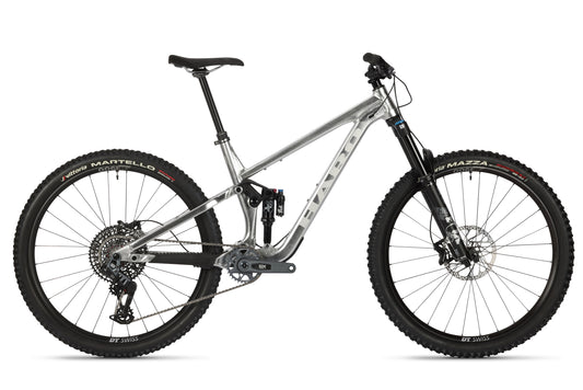 The Daley Alloy LTD 1 by Haro Bikes is a Limited Edition silver mountain bike featuring a full suspension frame with Fox Suspension, knobby tires, a black seat, versatile gear system, and disc brakes for off-road adventures. The brand name is prominently displayed on the frame.