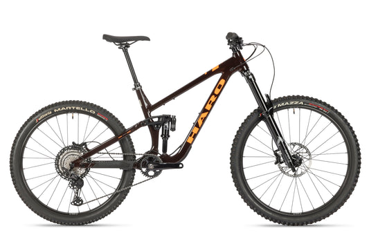 The Haro Bikes Greer Alloy 1 is a black and orange mountain bike with thick tires, sturdy frame, front and rear suspension, progressive Federung, disc brakes, and trail-ready components, making it ideal for rugged terrains.