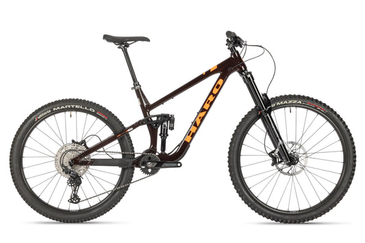 The Haro Bikes Greer Alloy 2 mountain bike boasts rugged tires, dual suspension, and disc brakes. Its frame features HARO in orange. With a gear system and comfy saddle, this mullet Radkonfiguration is ideal for off-road adventures.