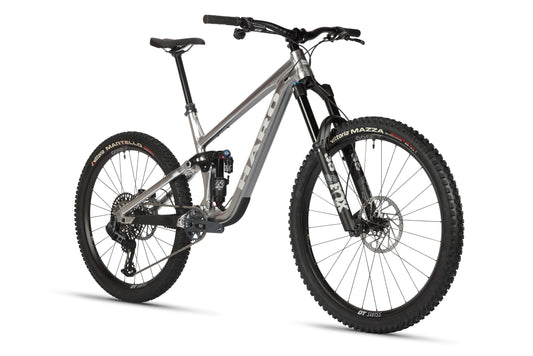 The Greer Alloy LTD 1 by Haro Bikes is a stylish mountain bike with a raw aluminum frame, large black tires, and a Fox suspension fork. It features disc brakes and a gear system, making it ideal for off-road adventures.