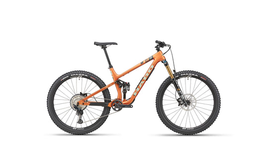 The Daley Carbon 2 by Haro Bikes: orange all-mountain carbon bike with Fox suspension, Shimano SLX, disc brakes, black tires on white.