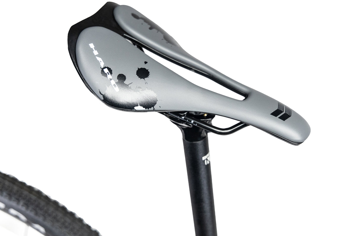 Grey Haro Buzzard Alloy LTD 2 bicycle saddle with a cutout and black ink-splatter graphics, mounted on a black seatpost.