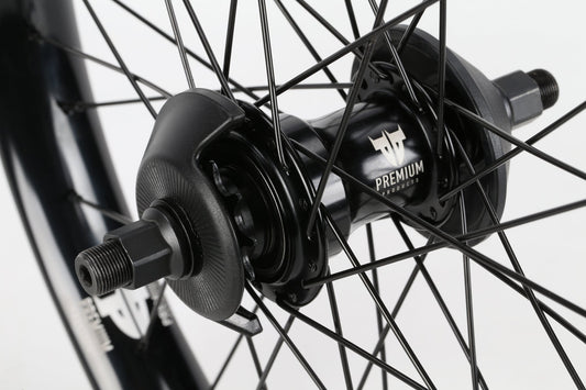 Close-up of a Premium Curb Cutter Freecoaster Rear Wheel, featuring black spokes and metal nuts against a sleek white background, highlighting the precision of its robust Freecoaster-Nabe for smooth rides.