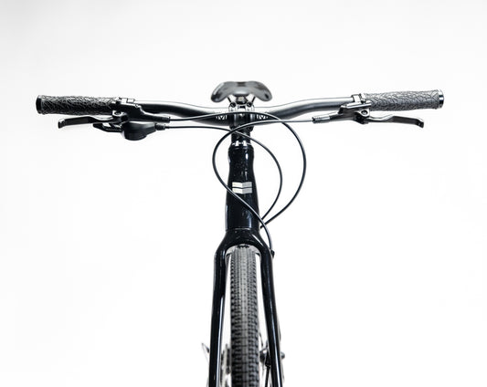 Front view of the Buzzard Alloy LTD 4 by Haro Bikes, showcasing its Shimano CUES U4000 handlebars and brake cables against a white background.