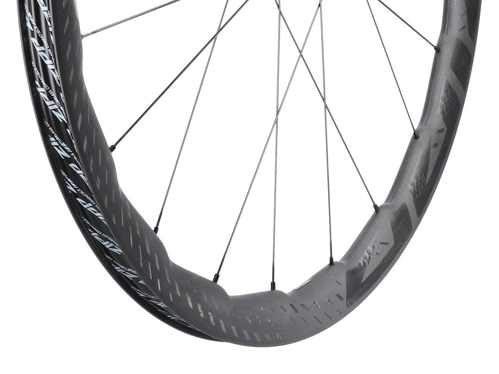 Close-up of Haro Bikes Wheelset Road Built Kit ZIPP 353 NSW with disc brake, deep carbon rim, and metal spokes on white background.