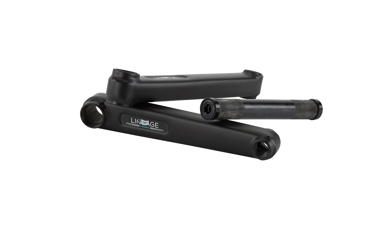 Three black metal bike crank arms labeled Lineage Kurbelgarnitur by Haro Bikes, with one lying horizontally and two upright.