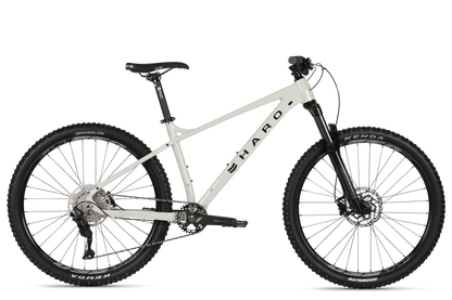 A white Haro Bikes Double Peak Comp 27.5 mountain bike features a sturdy frame, large tires, front suspension fork, and disc brakes with trail geometry design. Displayed on a plain background, it highlights its down-country performance capabilities.