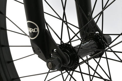 Close-up of a Leucadia BMX wheel from Haro Bikes, featuring black spokes and a shiny nut on the branded hub against a light background.