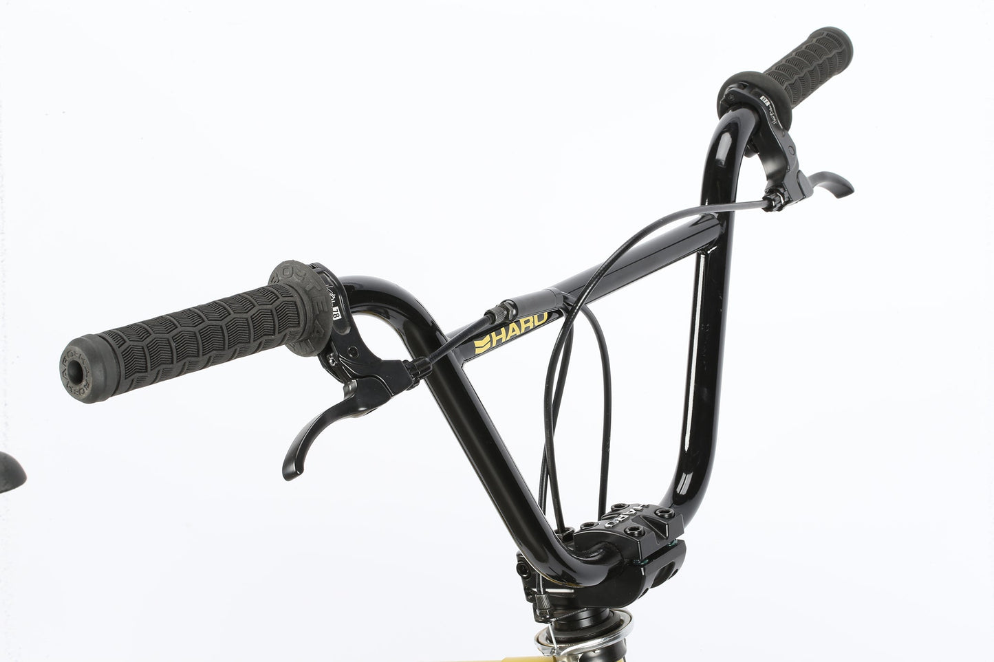 Close-up of black Leucadia DLX handlebars by Haro Bikes, featuring textured grips and brake levers against a white background.