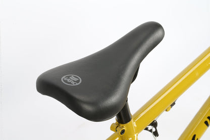 Close-up of a black bike saddle with a logo, mounted on a yellow Leucadia DLX frame by Haro Bikes against a white background.