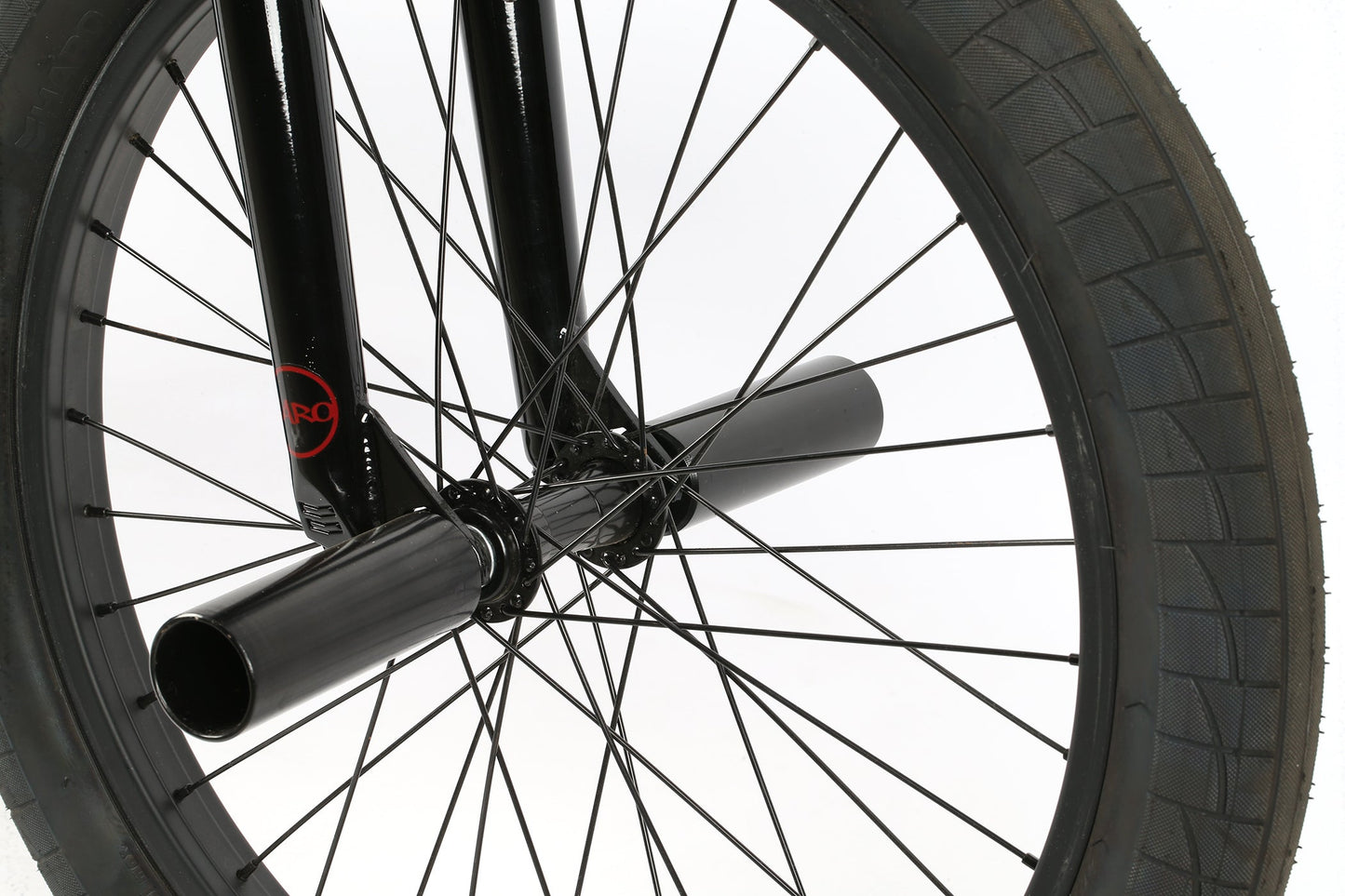 Close-up of a Leucadia DLX wheel by Haro Bikes, featuring black spokes and an axle peg, against a white background.