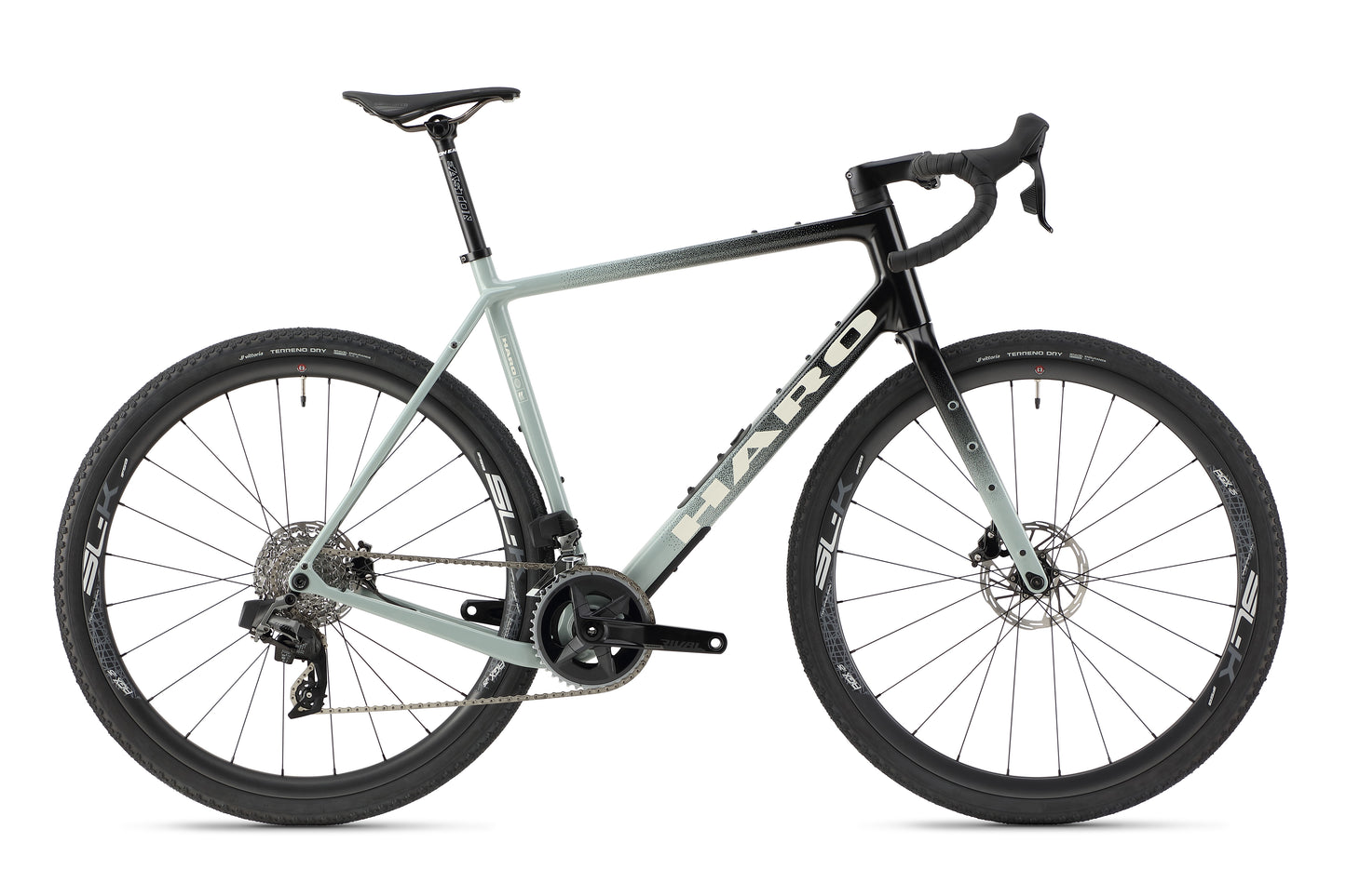 The Buzzard Carbon 1 by Haro Bikes is a sleek road bike in light gray and black, featuring a sturdy Carbonrahmen, drop handlebars, and Gravel-Reifen. It includes disc brakes and a Rival AXS Schaltgruppe gear system, perfect for both road and off-road cycling.