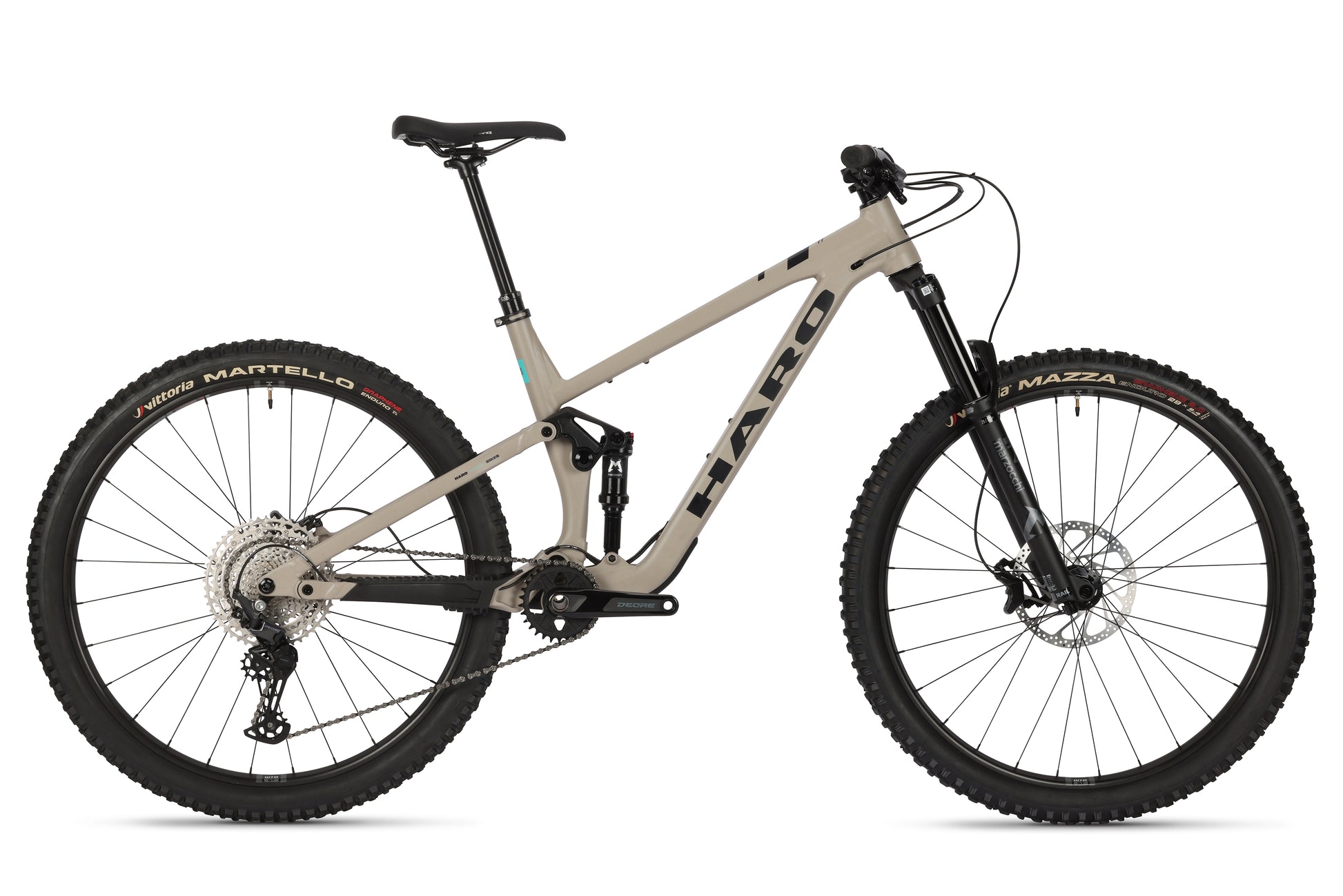 The Daley Alloy 2 from Haro Bikes is a beige All-Mountain-29er featuring a robust aluminum frame, front and rear suspension, 29-inch wheels, disc brakes, and black saddle and handlebars. The tires feature red text reading Martello and Mazza.