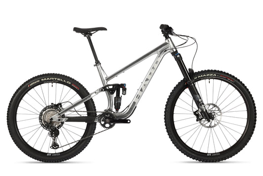 The Greer Alloy LTD 2 by Haro Bikes features a raw aluminum frame, full Fox suspension, and disc brakes. Its large Vittoria knobby tires and sleek design are optimized for off-road cycling.