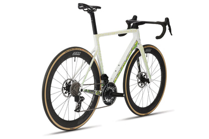 The Haro Bikes Rivette Carbon LTD, a limited edition bike designed by Mark Ward, features an aerodynamic build with disc brakes, drop handlebars, and deep-section wheels. Its sleek white frame with black and green accents offers a high-performance look.