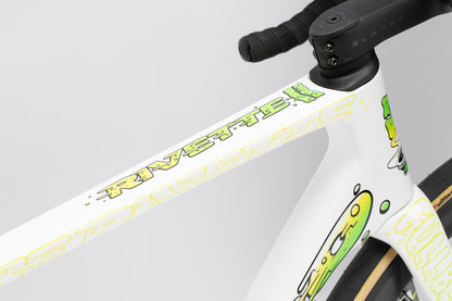 Close-up of a Rivette Carbon LTD frame by Haro Bikes, showcasing green and yellow graffiti-style graphics by Mark Ward on a mostly white frame. The partly visible handlebar highlights its limited-edition allure.