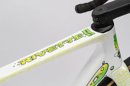 Close-up of a distinctive bicycle frame featuring a white, yellow, and green graffiti-style design with Riveretti on the top tube. Handlebars have dark textured tape. Designed by Mark Ward, this Haro Bikes Rivette Carbon LTD Road Bike is a limitierte Auflage masterpiece.