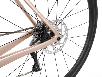 Close-up of the Rivette Carbon 2s race-ready wheel, featuring a disc brake and gear system on a sleek metallic frame by Haro Bikes. The image showcases intricate design and internal cable routing against a plain white background.