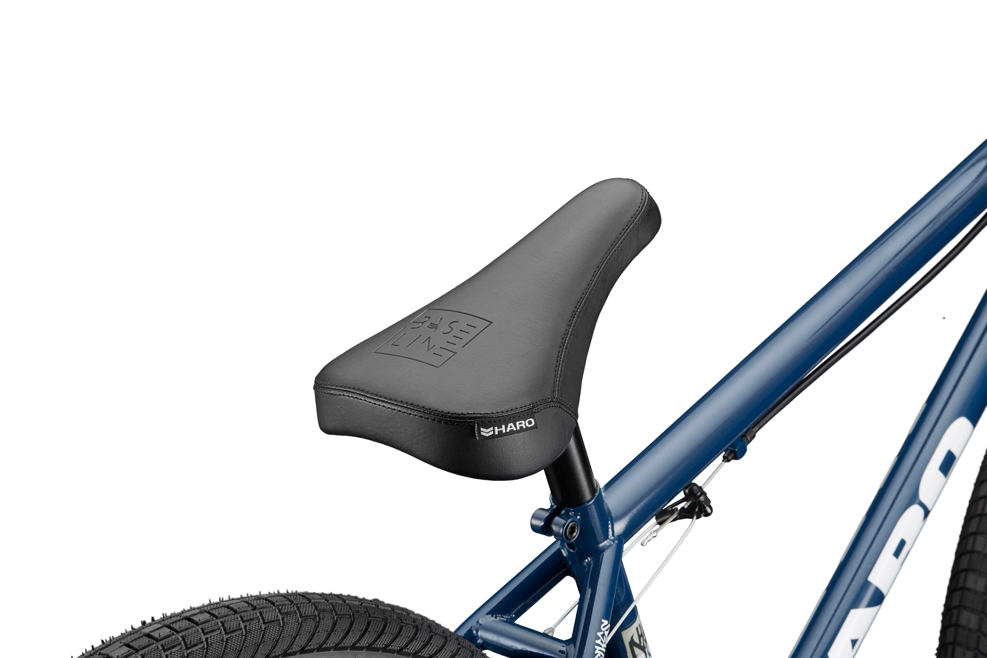 A close-up of a black seat on a blue Haro Bikes Downtown 24 BMX with 24 Zoll Laufräder, part of the rear tire in view.