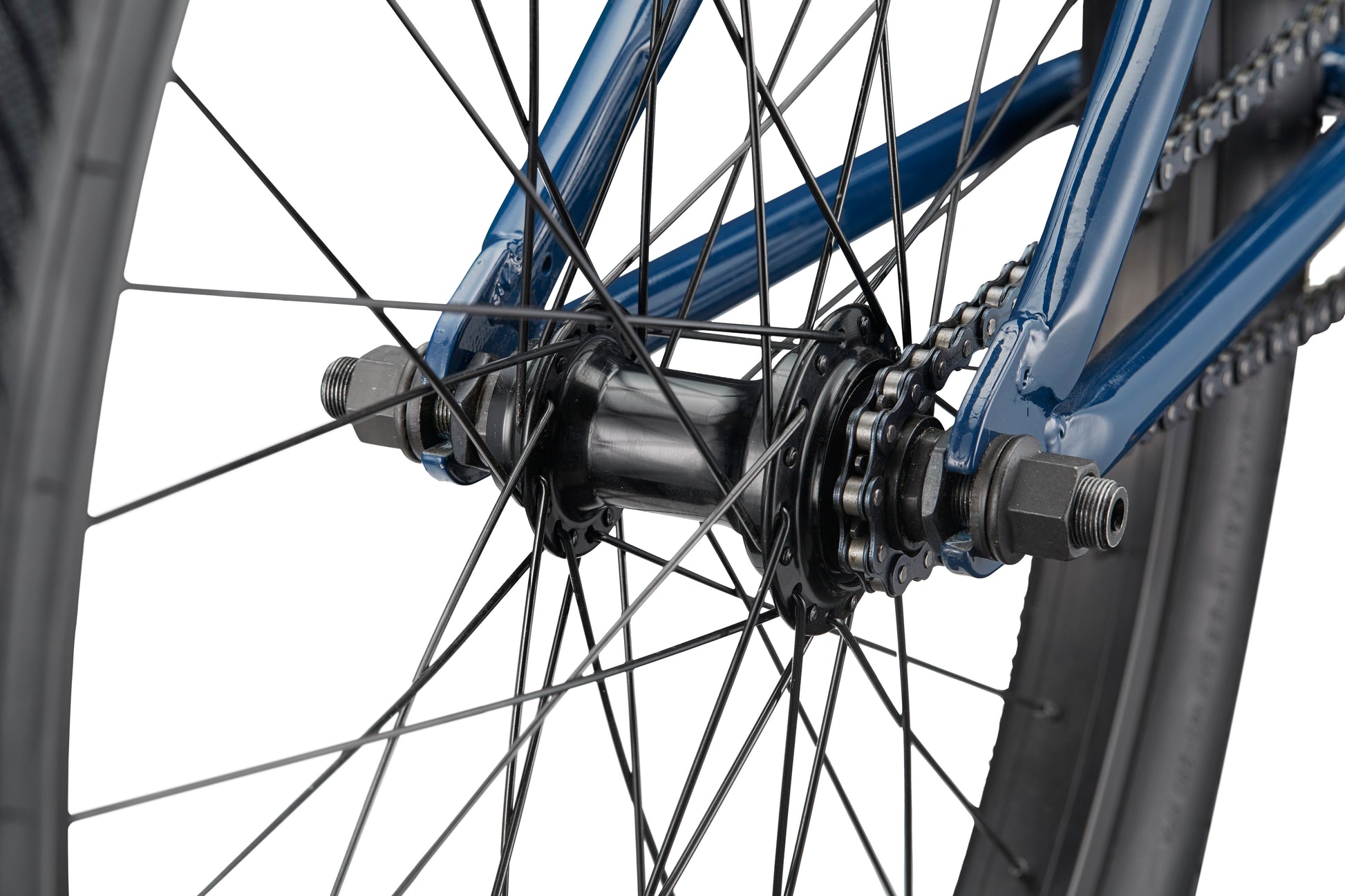 Close-up of a Haro Bikes Downtown 24 BMX rear wheel hub with spokes, axle, chain, and blue frame featuring 24 Zoll Laufräder.