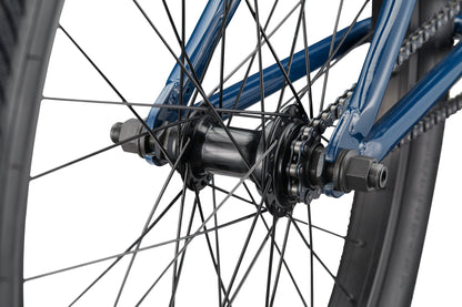 Close-up of a Haro Bikes Downtown 24 BMX rear wheel hub with spokes, axle, chain, and blue frame featuring 24 Zoll Laufräder.