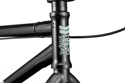 Close-up of a versatile Haro Bikes Downtown 24 BMX frame in black with light green logo, front brake cable, and 24" wheels.