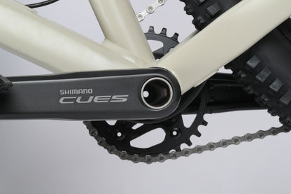 Close-up of a Haro Bikes Double Peak 1 crank arm and chainring with a chain, showcasing precision against a light background.