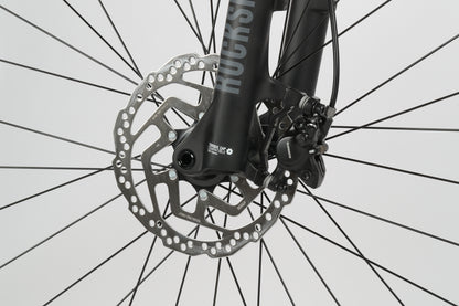 Close-up of Shimano hydraulic disc brakes on a bicycles black RockShox suspension fork, Haro Bikes Double Peak 1.