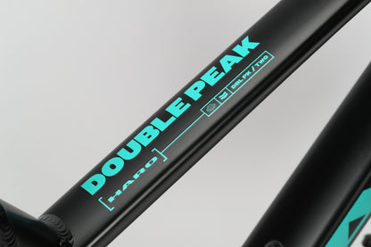 Close-up of the Double Peak 2 by Haro Bikes, aluminum frame with Double Peak and Haro in light blue on a sleek black background.