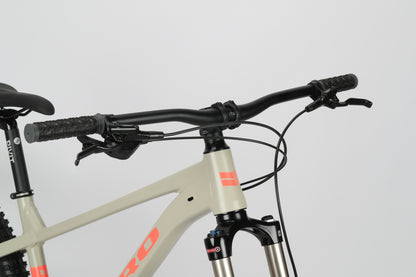 Close-up of the Haro Bikes Double Peak 2s front section with black handlebars, brake cables, a light gray aluminum frame, red accents, and disc brakes.