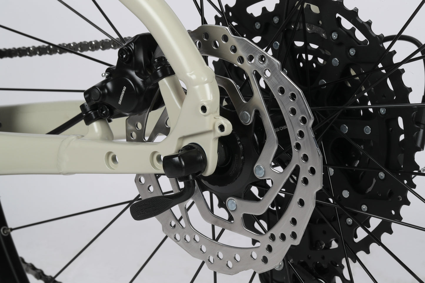 Close-up of the Double Peak 2s rear disc brake by Haro Bikes, showing Shimano Cues 1x10 Schaltung, wheel spokes, and gear cassette.