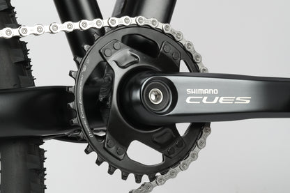 Close-up of Double Peak 3 crankset and chain by Haro Bikes, showcasing gear teeth against the bike frame.