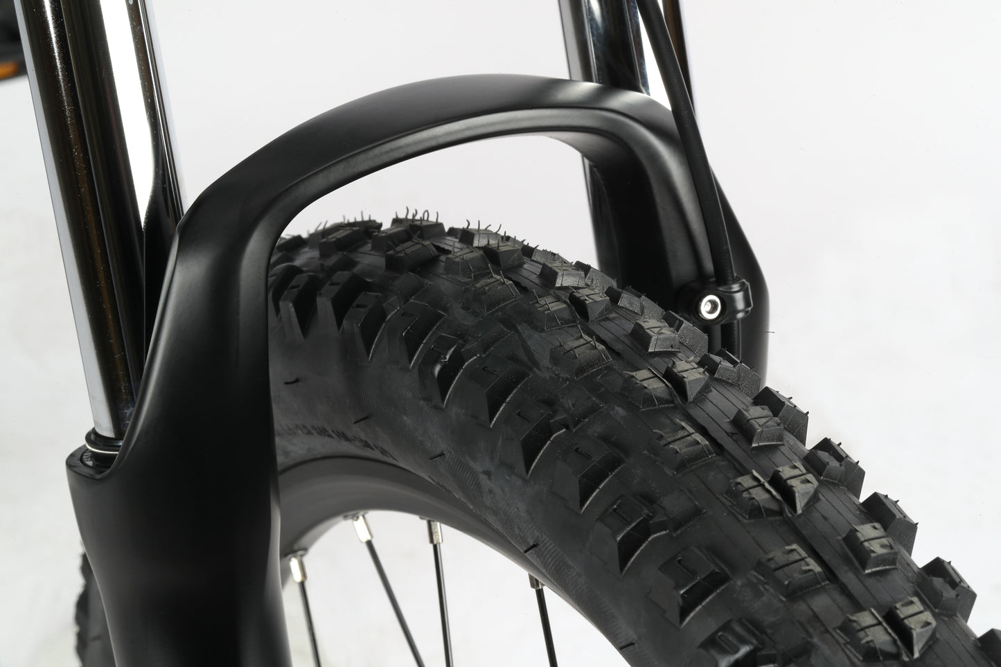 Close-up of the Haro Bikes Double Peak 3 with a black suspension fork and knobby tire for rough terrain, against a plain background.