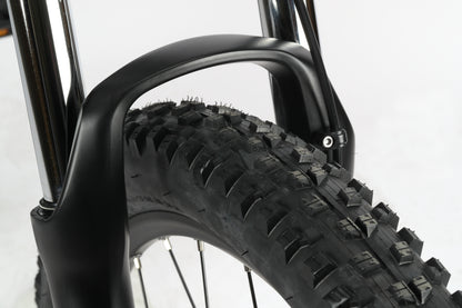 Close-up of the Haro Bikes Double Peak 3 with a black suspension fork and knobby tire for rough terrain, against a plain background.