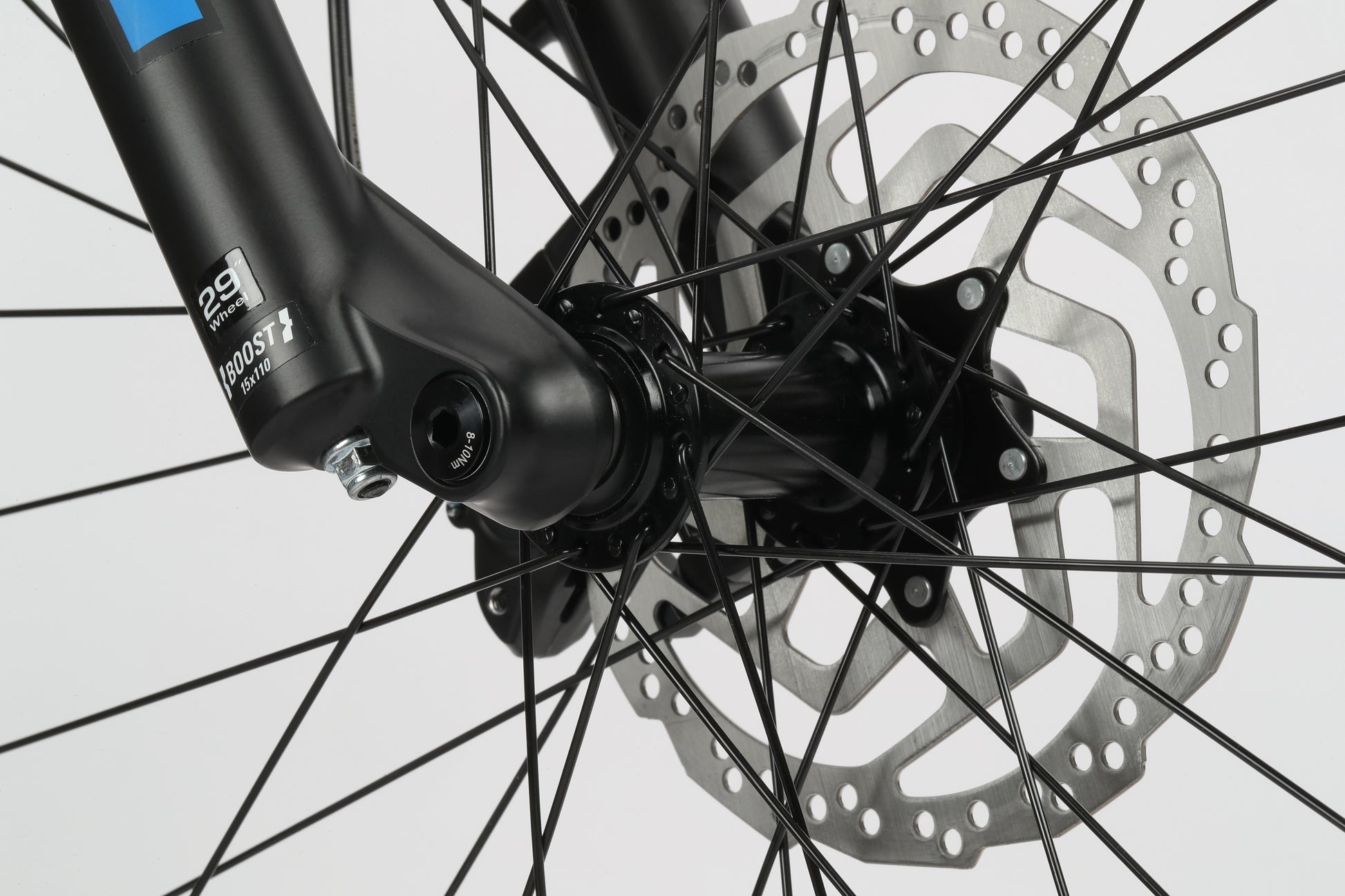 Close-up of Double Peak 3s black-spoked wheel hub and silver disc brake rotor by Haro Bikes against a plain background.