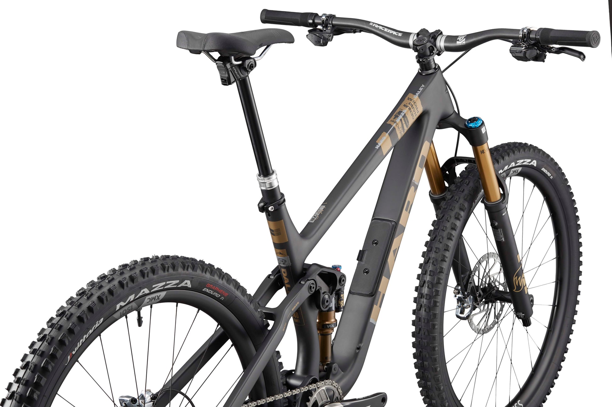 The Haro Bikes Daley Carbon Top Shelf is a matte gray, full-suspension carbon all-mountain bike with gold accents, shown from the rear.