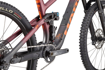 Close-up of the Haro Bikes Greer Carbon 1’s rear suspension, chain, crankset, and maroon-black frame with Fox-Fahrwerk.