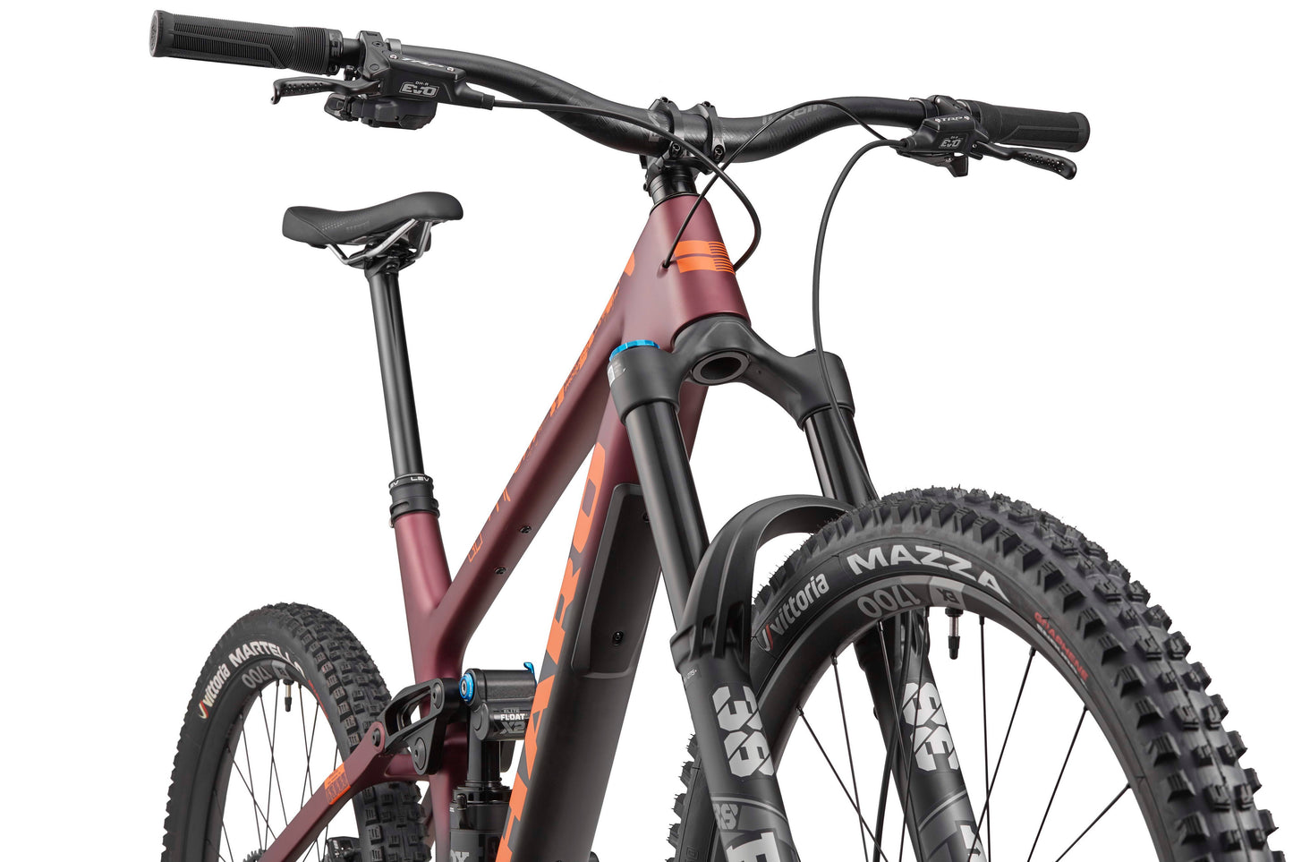 Close-up of the Haro Bikes Greer Carbon 1 Enduro with Fox suspension, thick tires, and a maroon frame from a low front angle.