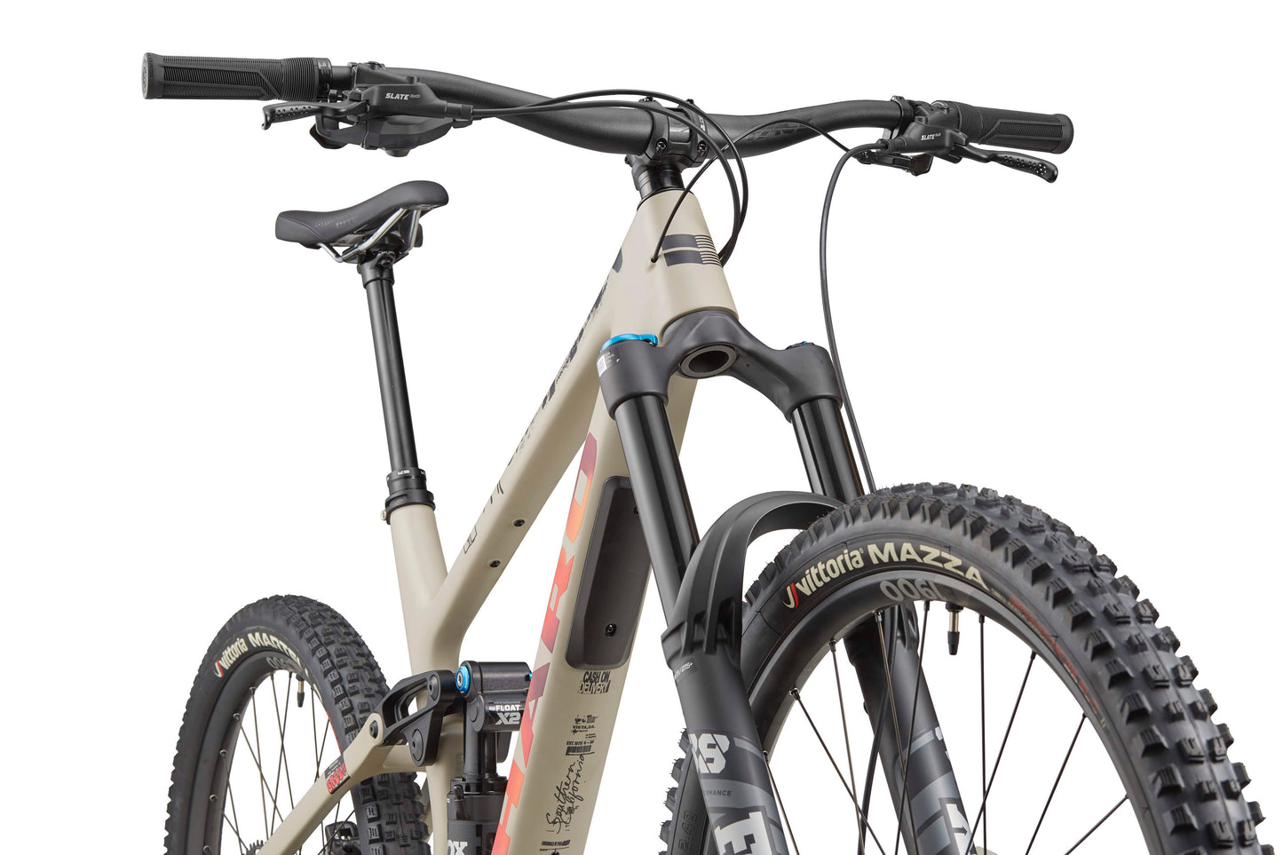 Close-up front angle of a beige Haro Bikes Greer Carbon 3 with knobby tires, front suspension, and flat handlebars on white background.