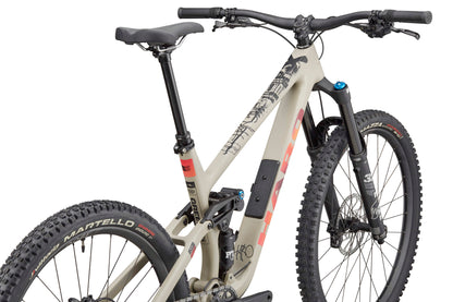 The Haro Bikes Greer Carbon 3 is a tan enduro bike with trail agility, black bars, thick tires, and a graphic top tube.