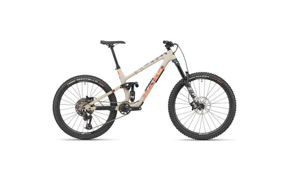 The Haro Bikes Greer Carbon 3 is a beige endurobike with black-orange accents, knobby tires, and disc brakes for trail agility.