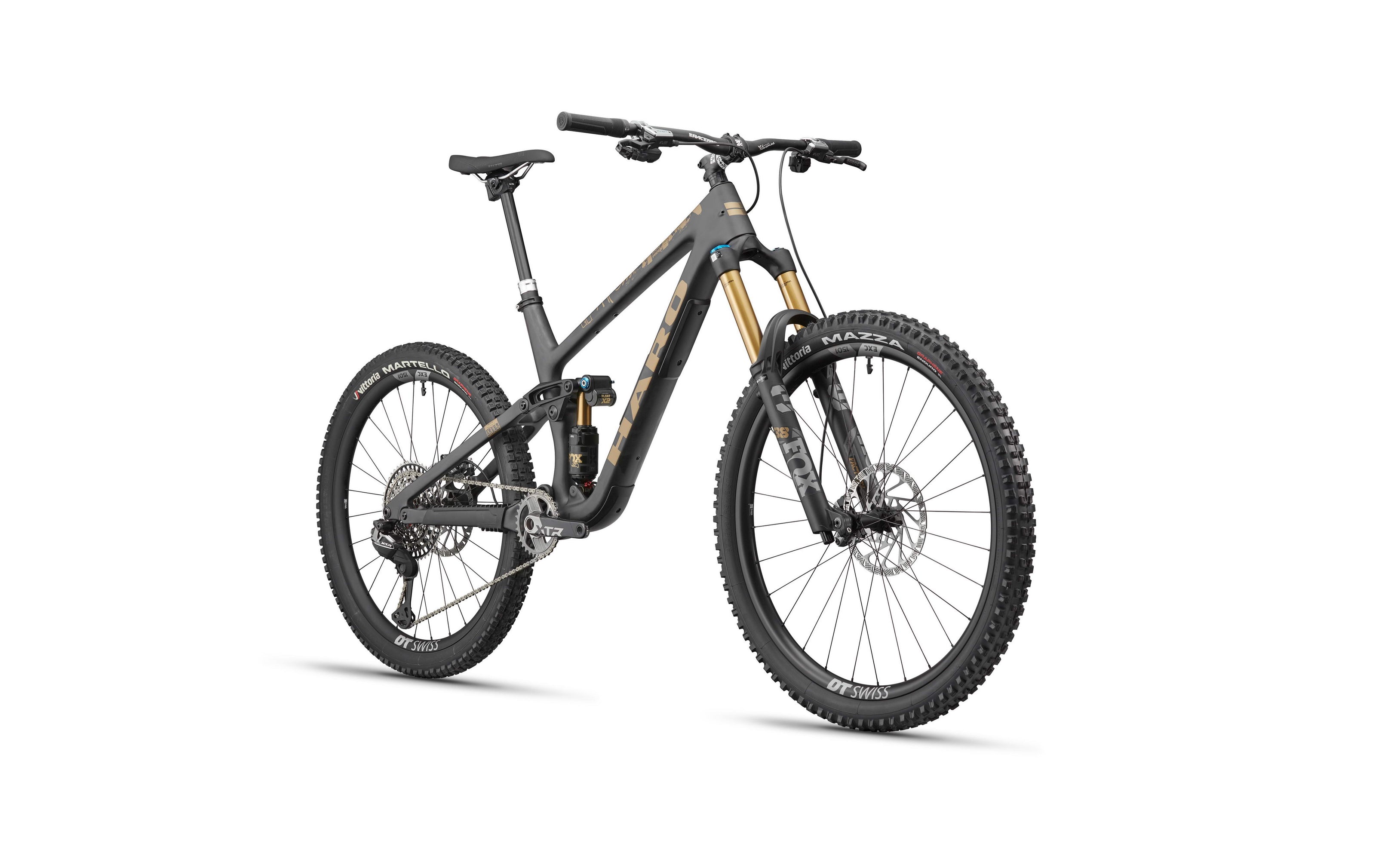 The Haro Bikes Daley Carbon Top Shelf is a matte dark carbon all-mountain bike with disc brakes and thick tires, shown on white.