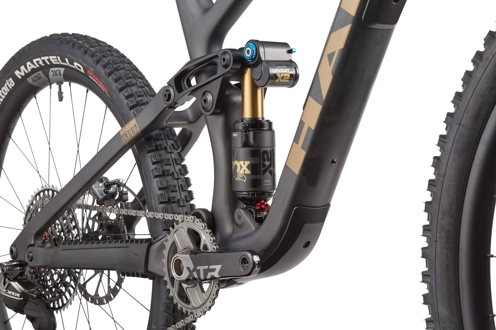 Close-up of a Haro Bikes Greer Carbon Top Shelf’s rear suspension, FOX shock, XTR crankset, and tire on this carbon mountain bike.