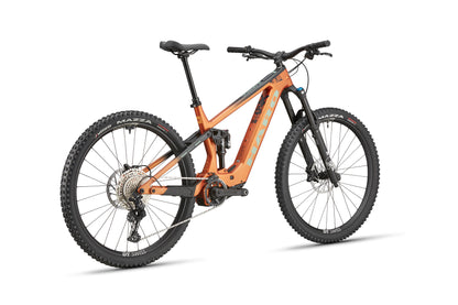The Haro Bikes eDaley Carbon 2 is a full-suspension mountain bike with wide knobby tires, disc brakes, and a sturdy frame, rear-side view.