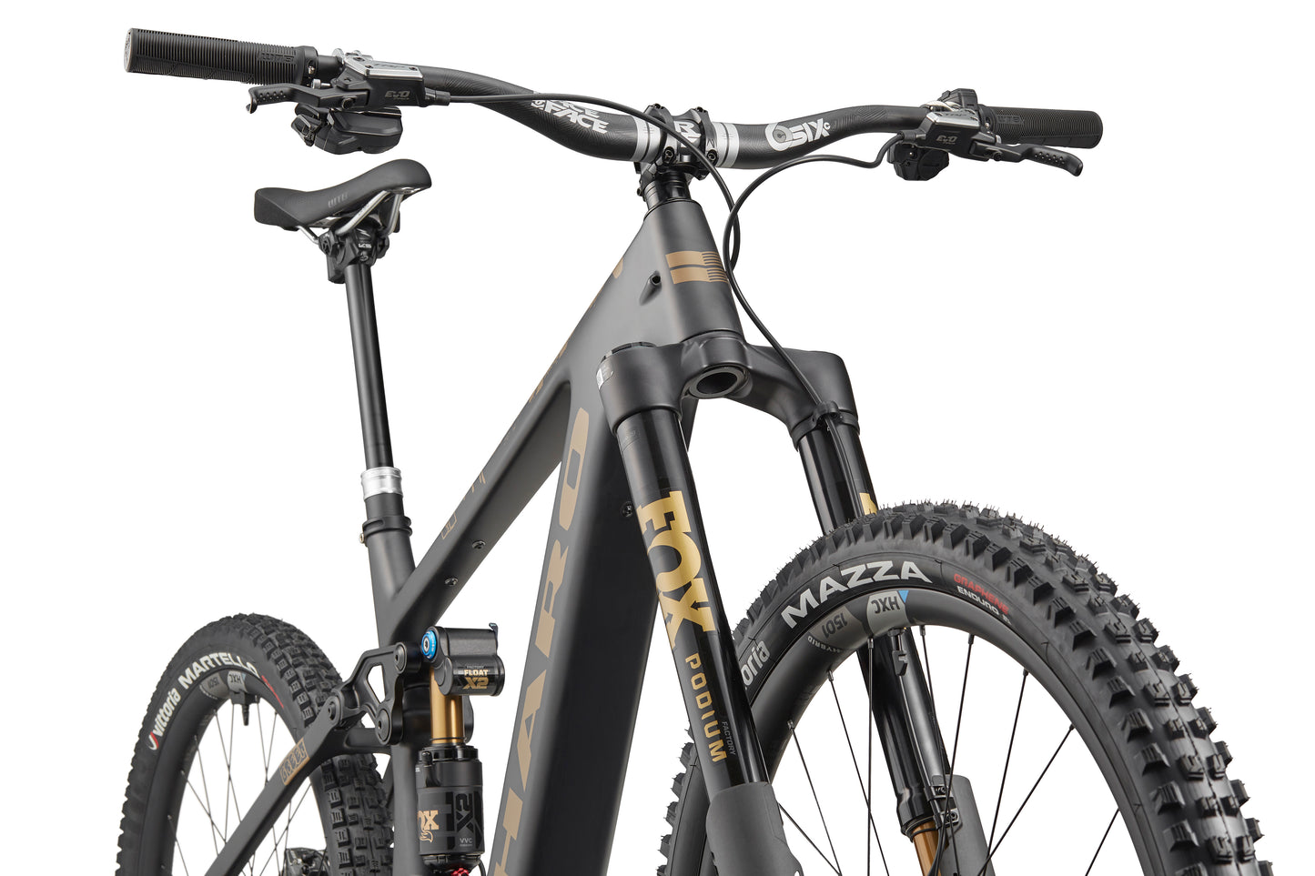 Close-up of the Haro Bikes eGreer Carbon Top Shelf E-Bike: thick tires, front suspension, carbon frame in matte black and gold, front angle.