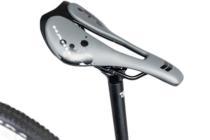 Grey Haro Buzzard Alloy LTD 2 bicycle saddle with a cutout and black ink-splatter graphics, mounted on a black seatpost.