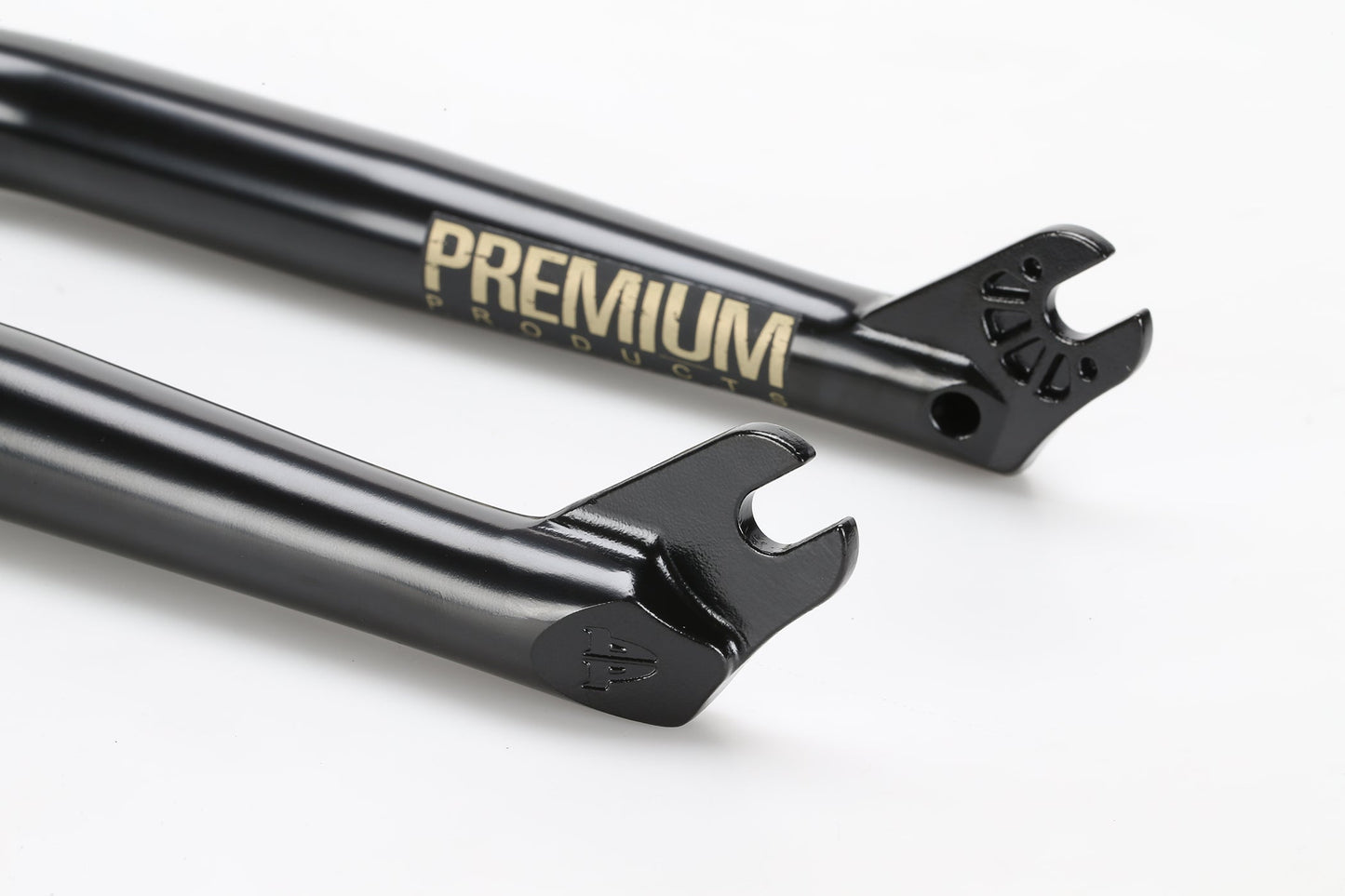 Close-up of two sleek black CK V2 Fork dropouts, crafted from durable Chromoly steel. The Premium branding is elegantly printed in gold on the upper section, featuring a CNC-machined steerer tube against a plain white background.