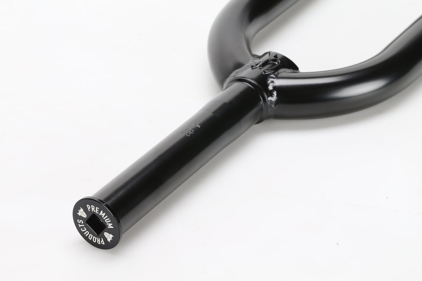 Close-up of a black CK V2 Fork from Premium, lying on a white surface. It features a smooth, glossy finish with PREMIUM engraved on the end of its CNC-gefräster Gabelschaft steerer tube.