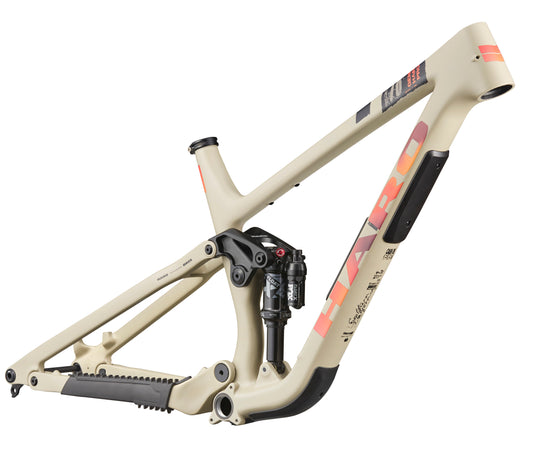 Beige Daley Carbon Frameset by Haro Bikes with orange branding and rear shock absorber installed.